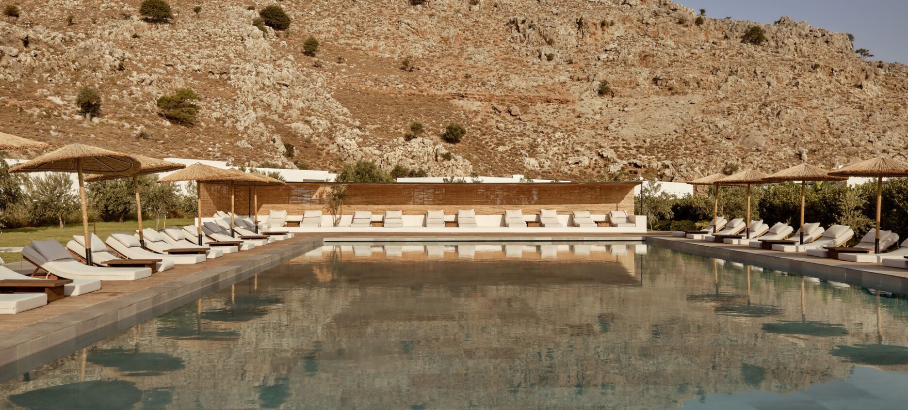 Serene outdoor pool with sun loungers and mountain views at Casa Cook Rhodes, a boutique adults-only hotel in Kolymbia offering a peaceful escape on the island of Rhodes