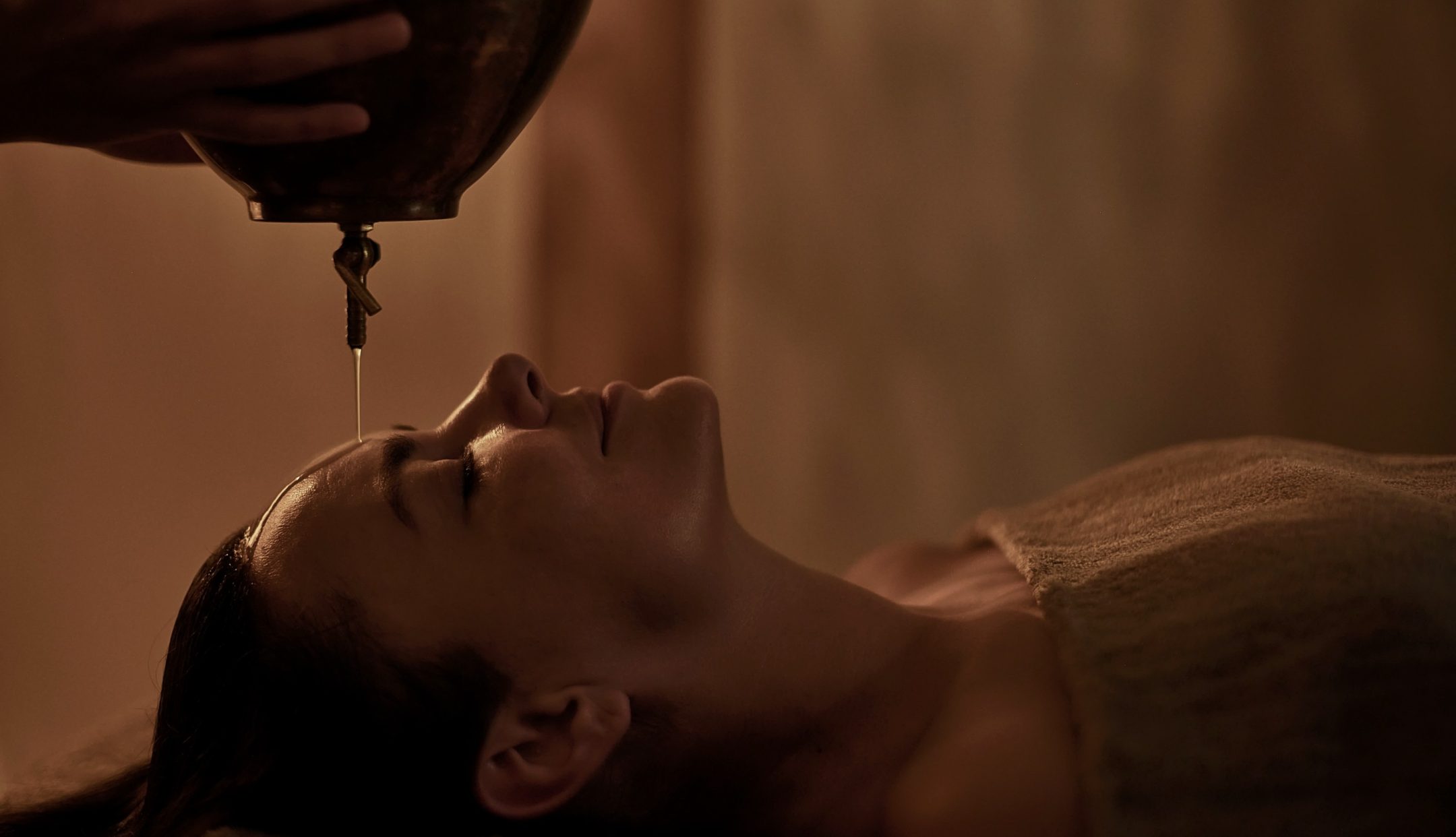 Guest receiving a Shirodhara treatment at Casa Cook Rhodes, where warm oil is gently poured onto the forehead as part of a calming wellness ritual in a tranquil adults-only retreat