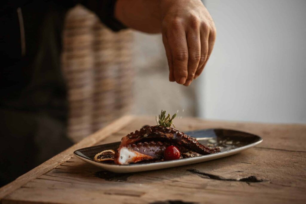 Delicious seafood being salted and final touches added before being served