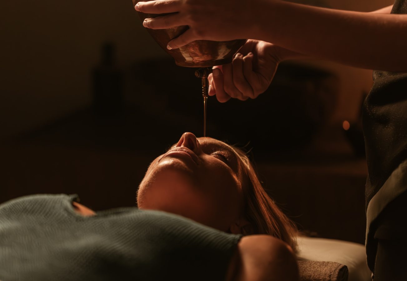 Guest receiving a Shirodhara treatment at Casa Cook Rhodes, where warm oil is gently poured onto the forehead as part of a calming wellness ritual in a tranquil adults-only retreat