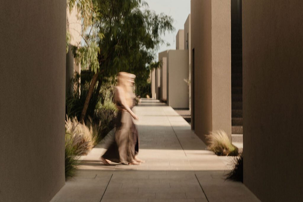 Sofia caught walking in slow motion between the buildings of Casa Cook Samos