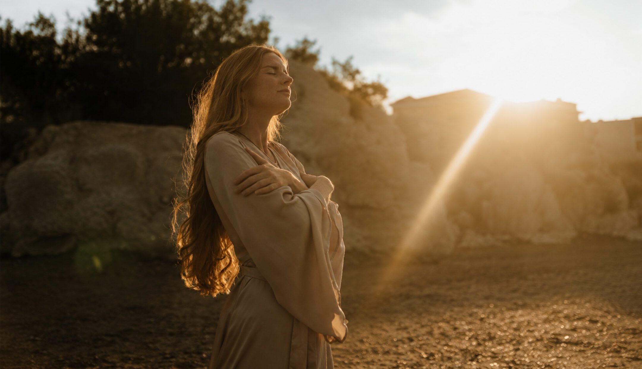 woman looking out at the horizon with the sun setting in the background
