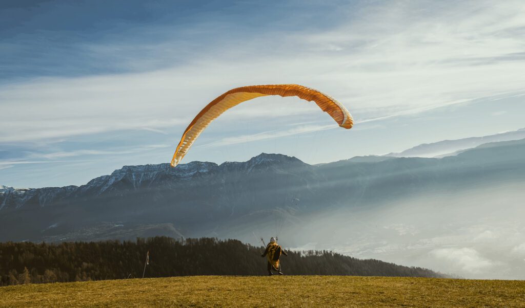 A person landing from paragliding on a clear sunny day.
