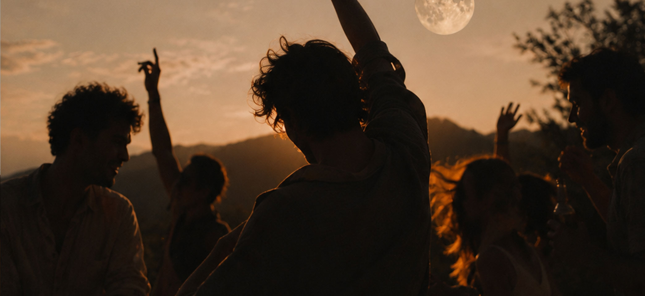Full moon party, people dancing with their arms up in the air