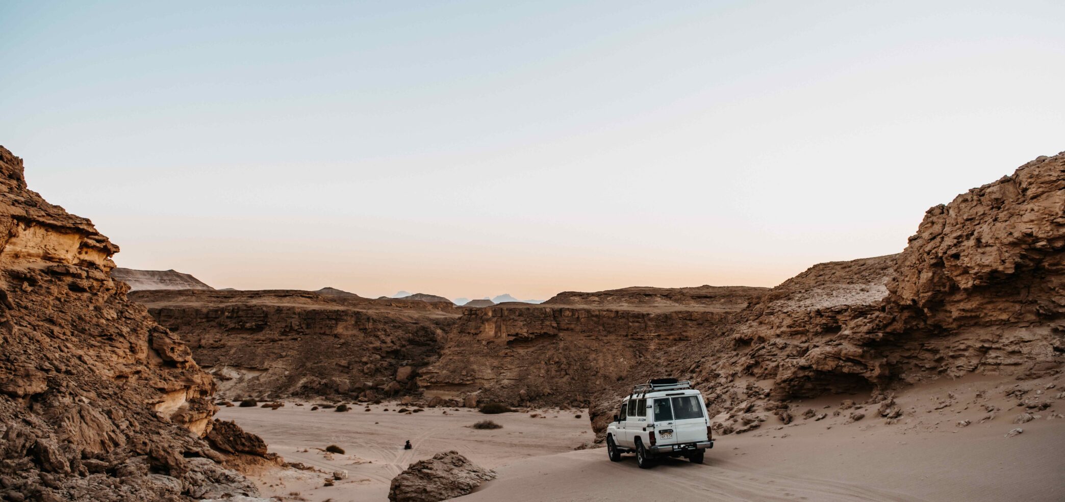 Car driving through the desert for the sunset experience